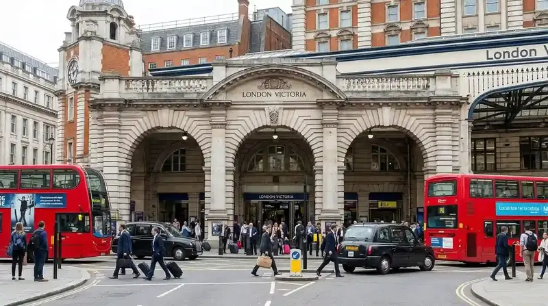 The stone front of London Victoria station with red buses outside
